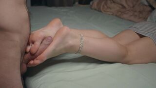A petite girl shows her small feet and performs a footjob