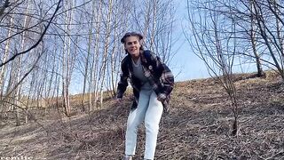 A girl is walking in the woods and suddenly gets frisky