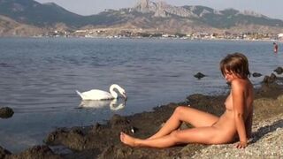 A girl walked on the riverbank without any clothes on