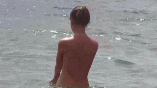 Nudists enjoy each other’s company on a hot sunny beach