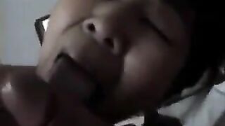 A Chinese woman practices her blowjob skills on her bed