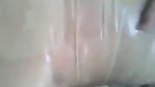 A man masturbates his cock with his hand covered with a condom