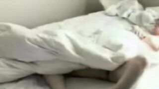 A hidden camera secretly photographs a person masturbating in bed