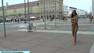 A hot chick walks the streets of the city completely naked