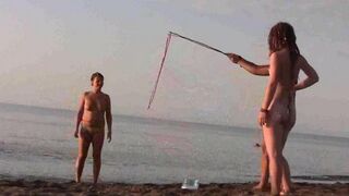 Nude beauty playing on the sandy beach