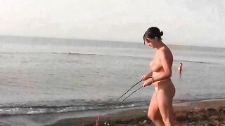 Nude beauty playing on the sandy beach
