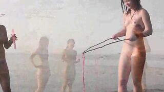 Nude beauty playing on the sandy beach
