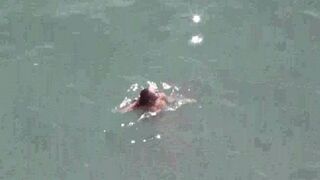 A pair of naked people enjoy each other on the sea