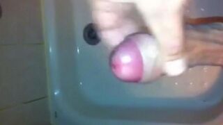The kid caresses his dick under the shower with his hand until the end