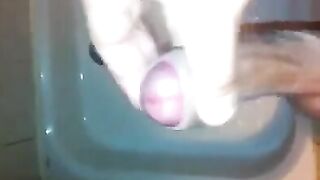 The kid caresses his dick under the shower with his hand until the end