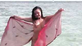 A girl has a bath in the sea naked. It's very refreshing!