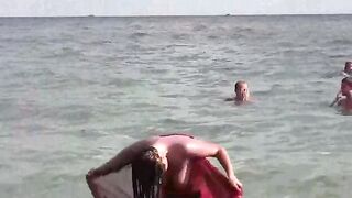 A girl has a bath in the sea naked. It's very refreshing!