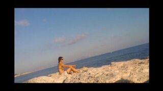 A girl has a sunbath directly on the bare beach