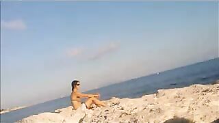 A girl has a sunbath directly on the bare beach