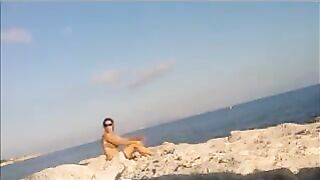 A girl has a sunbath directly on the bare beach