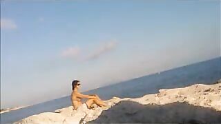 A girl has a sunbath directly on the bare beach
