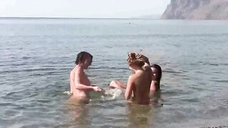A group of nudists enjoy fun on the naked beach