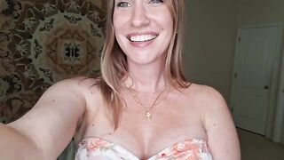 A woman is massaging her boobs with shimmering oil