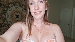 A woman is massaging her boobs with shimmering oil